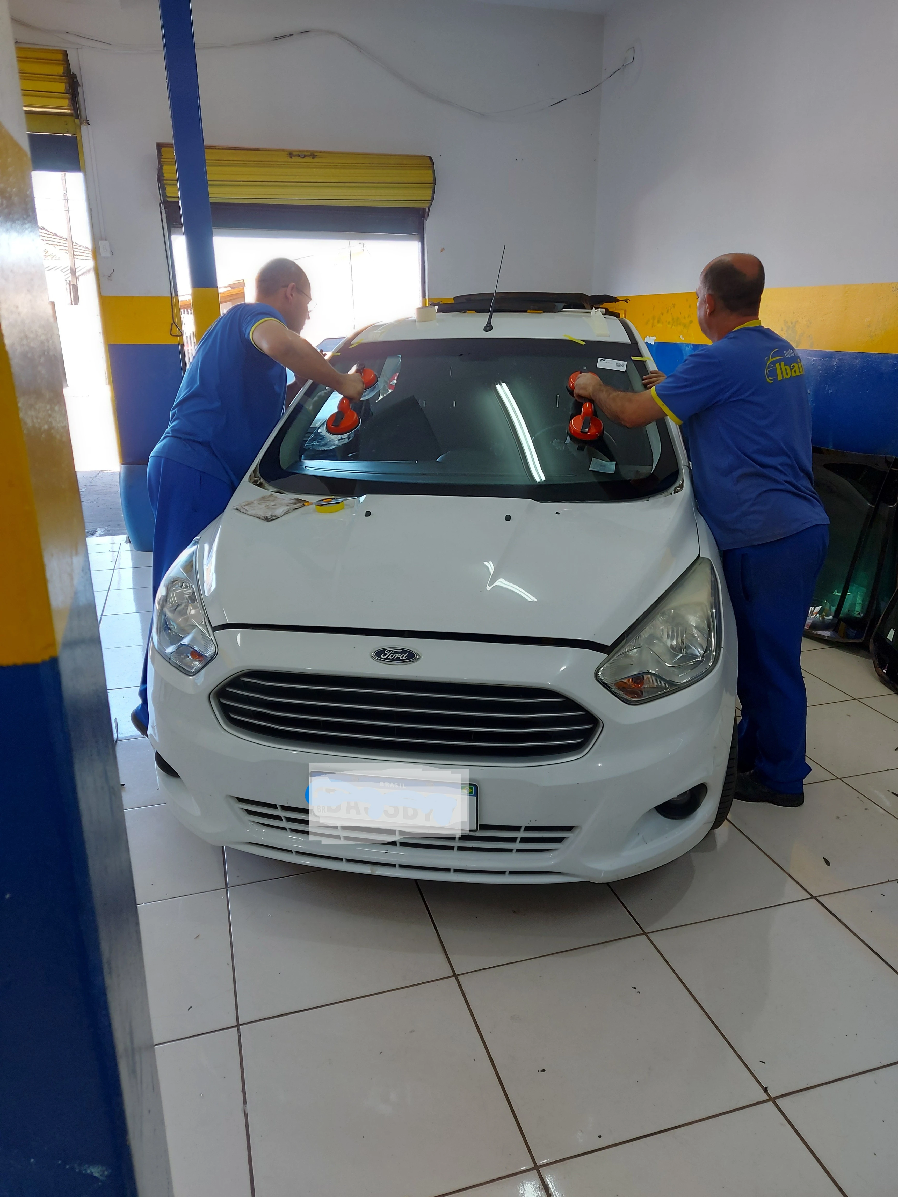 Instalação de para-brisa em veículo branco